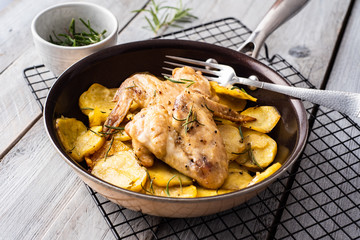 Baked chicken wings and potato chips with rosemary and garlic