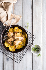 Baked chicken wings and potato chips with rosemary and garlic