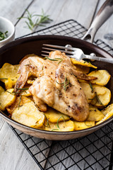 Baked chicken wings and potato chips with rosemary and garlic