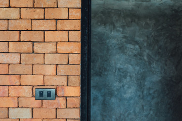 Double electrical light switch on red brick wall texture and concrete background
