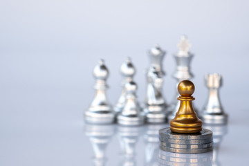 A chess stand on stack of coins as a true winner.Money game concept. Copy space.