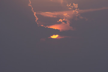 Beautiful sun. The sun is hiding behind the clouds. Perspective.