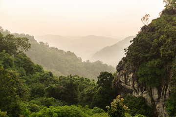 Beautiful mountain landscape with sunset. View of foggy hills covered by forest.