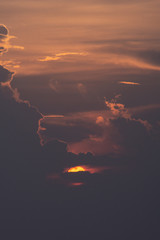 Beautiful sun. The sun is hiding behind the clouds. Perspective.