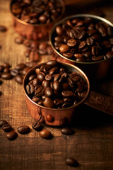 Kaffeebohnen in Schalen auf Holztisch vertikal