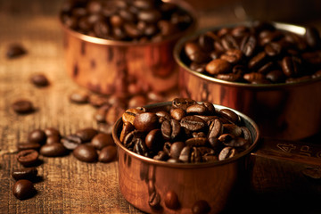 Fototapeta premium Kaffeebohnen in Schalen auf Holztisch horizontal