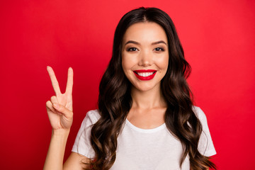 Close-up portrait of her she nice-looking attractive pretty charming glamorous lovely cheerful cheery wavy-haired girl showing v-sign isolated over bright vivid shine vibrant red color background