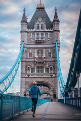 Obraz premium Runner in the morning training on the Tower Bridge in London. Sport in City, concept photo