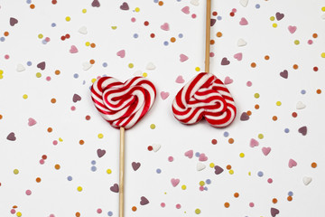 Valentin's day background. Two heart shape sweet lollipop on abstract background with little...