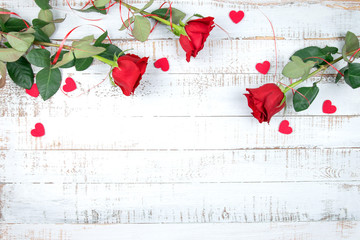 Red roses with hearts on a white wooden background, flat lay, for text.Valentine's Day