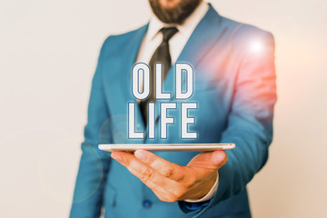 Conceptual hand writing showing Old Life. Concept meaning the way I was in the past before some important change happened Businessman in blue suite with a tie holds lap top in hands