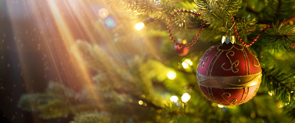 Christmas ball on christmas tree with lights in background, bokeh