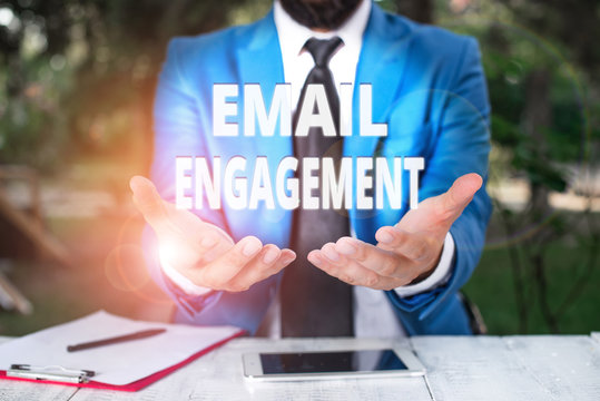Text sign showing Email Engagement. Business photo showcasing measure how subscribers engage in the email campaigns Man with opened hands in fron of the table. Mobile phone and notes on the table