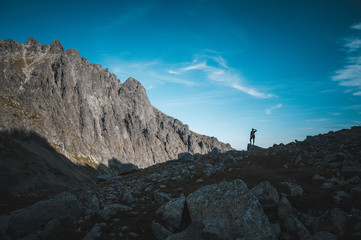 Fototapeta premium silhouette of female hiker. Hiking, adventure in mountains sport photo, edit space