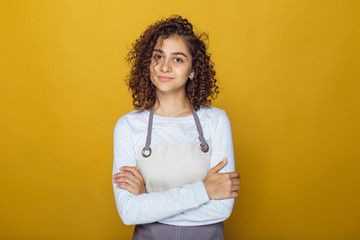 Portrait of a friendly young indian woman in apron. Cook, pastry chef.