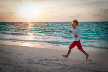 Fototapeta na wymiar happy little boy run and play at sunset beach