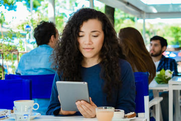 Young woman with tablet in coffee shop.