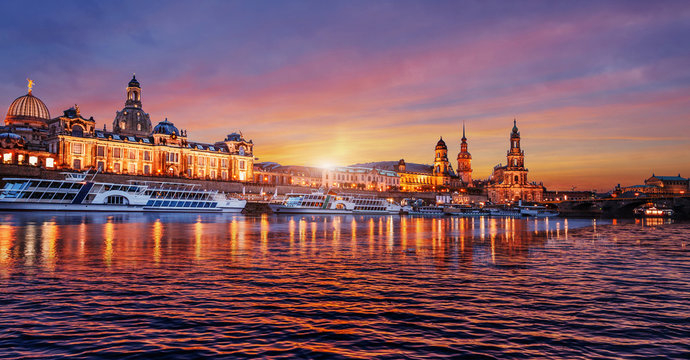 Wonderful colorful sunset over the famouse Old Town architecture in Dresden, with Elbe river embankment with reflections. Colorful sunset  in Dresden, Saxony, Germany, Europe. Creative image.