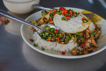 Thai rice topped with stir-fried pork hot chilli and basil with cabbage and fried egg.	