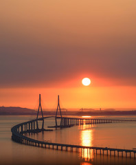 Fototapeta na wymiar Sun setting over the Incheon Airport Bridge in South Korea