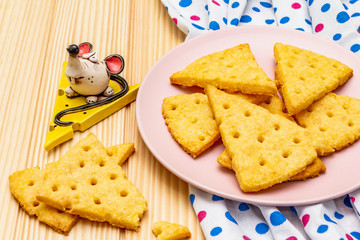Funny kids cookies. Festive cheese crackers, New Year snack concept. Food, mouse sculpture, napkin. Wooden planks background