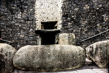 Entry of New grange passage tomb and stones carved with tri spiral pattern