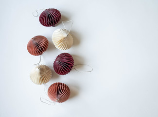 Multicolored pastel paper origami Christmas decorations frame on a white background. Top view. Copy space