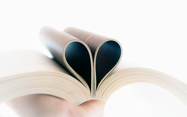  Open book with curled leaves in the shape of a heart.