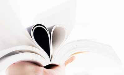  Open book with curled leaves in the shape of a heart.
