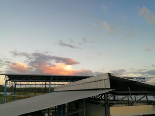 Fototapeta premium The evening sky as the sun sets Above the factory roof