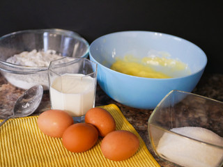 Ingredients for baking dough. flour, eggs, milk. Baking ingredients. Spoon on a marble table. Preparation for cooking.