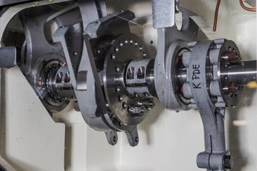 Close up of an industrial engine machine in a factory with cogs pistons bearings metal shiny greased lubricated machinery operated with health and safety by working class workers production