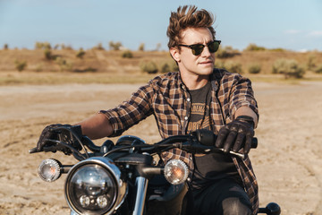 Man biker on bike outdoors at the desert field.