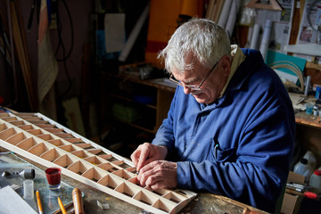 Senior man makes the wing of a radio-controlled aircraft, the construction of the airplane.