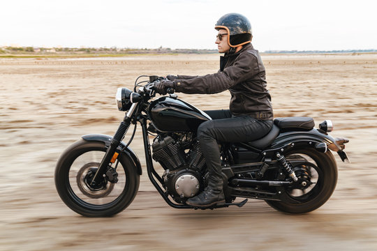 Young Man Biker On Bike Outdoors At The Desert Field.