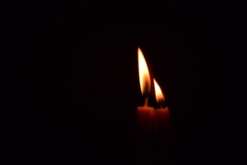The candle light shines in the dark room.