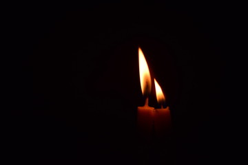 The candle light shines in the dark room.