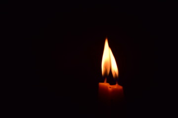 The candle light shines in the dark room.