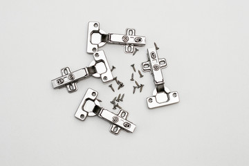 Four furniture awnings and screws on a white background. Steel furniture fittings.