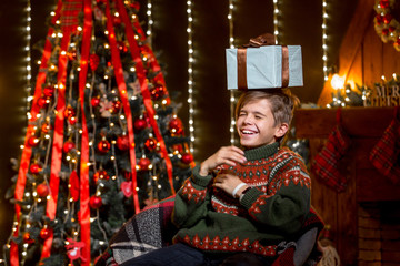 Obraz na płótnie Canvas Happy little smiling boy with christmas gift box