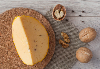 slice cheese with walnuts on wooden background