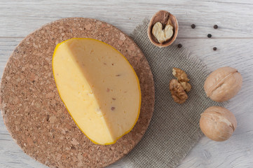 slice cheese with walnuts on wooden background