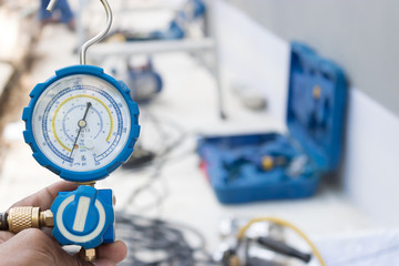 Technicians use manifold gauges to check the refrigerant pressure of air conditioners.