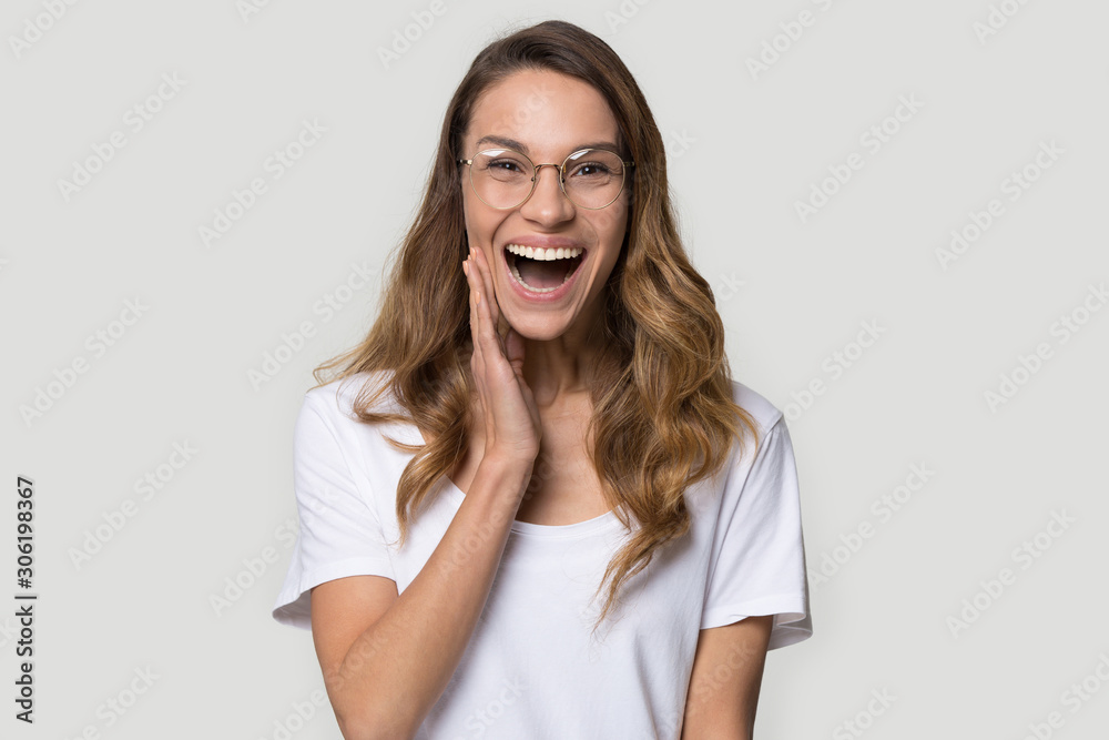 Wall mural Happy surprised young woman wearing glasses with open mouth