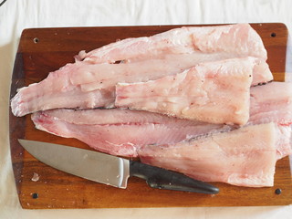 pike fish fillet on a cutting board with ingredients for cooking