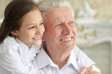 Portrait of happy elderly man with cute granddaughter