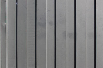 Gray metal gate with vertical lines closeup