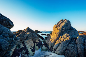 sunset over the sea on a rocky beach