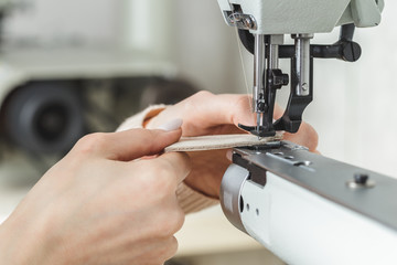 Woman stitching leather using a sewing machine