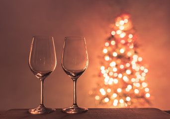 Wine glasses and Christmas tree in the background. Christmas holiday concept. 